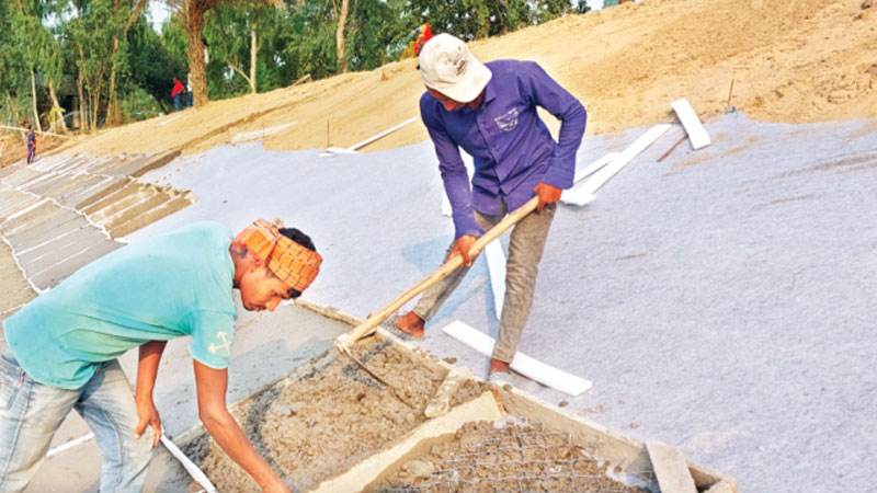 গাছের গুঁড়ির ওপর ঢালাইয়ে চলছে সড়ক রক্ষার কাজ গাছের গুঁড়ির ওপর ঢালাইয়ে চলছে সড়ক রক্ষার কাজ