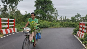 জং ধরা সাইকেলে গাছ বিলানো তরুণ